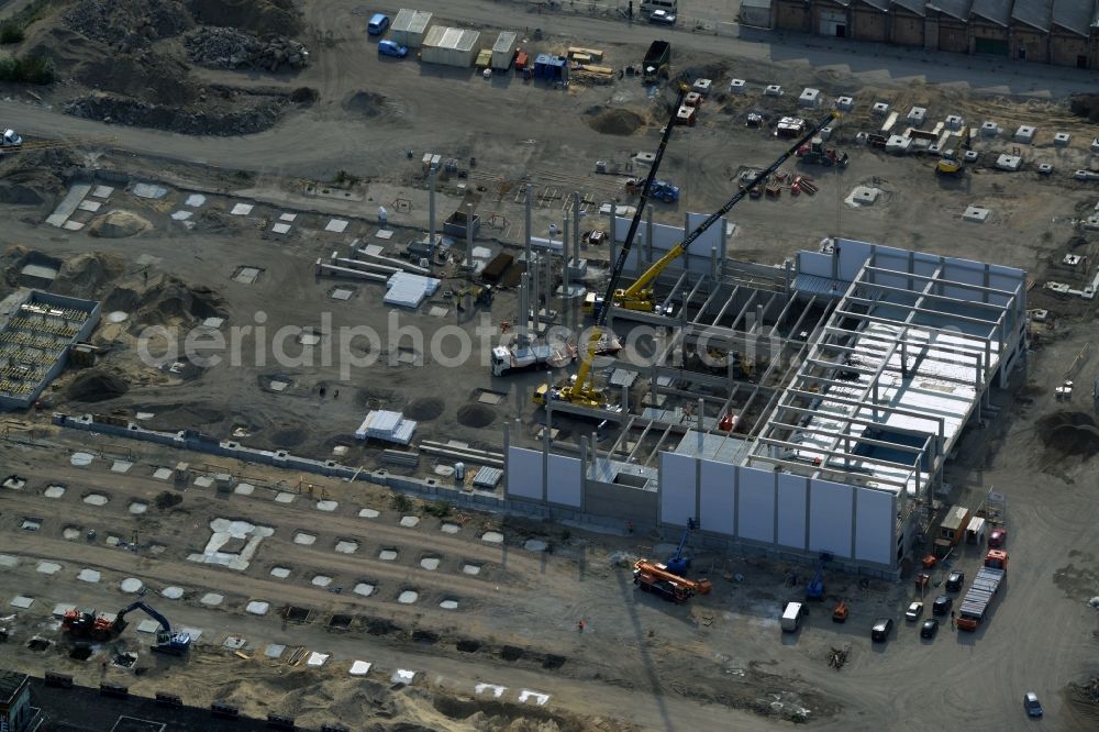 Berlin from the bird's eye view: Construction site for the new building of a commercial area with stores on Schnellerstrasse in the Niederschoeneweide part of the district of Treptow-Koepenick in Berlin in Germany. The area is being developed on the Spree riverbank in the renovation and redevelopement area of Treptow-Niederschoeneweide