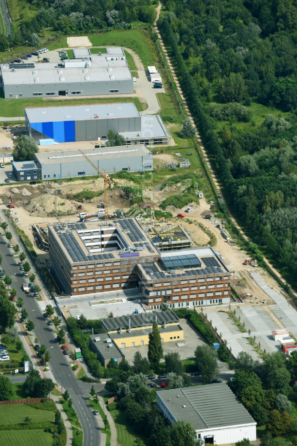 Berlin from above - Construction site of the new company building of Flexim GmbH with a wooden facade on Boxberger Strasse in the district of Marzahn-Hellersdorf in Berlin