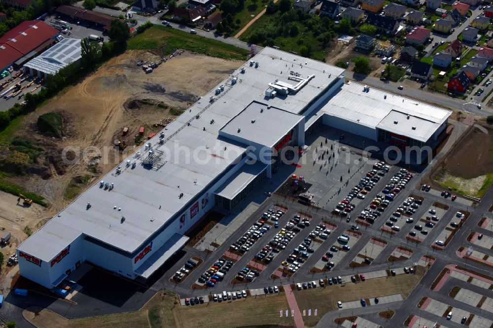 Berlin from the bird's eye view: Construction site for the new building home-center of the Porta-Group at Pilgramer street in the district Mahlsdorf in Berlin