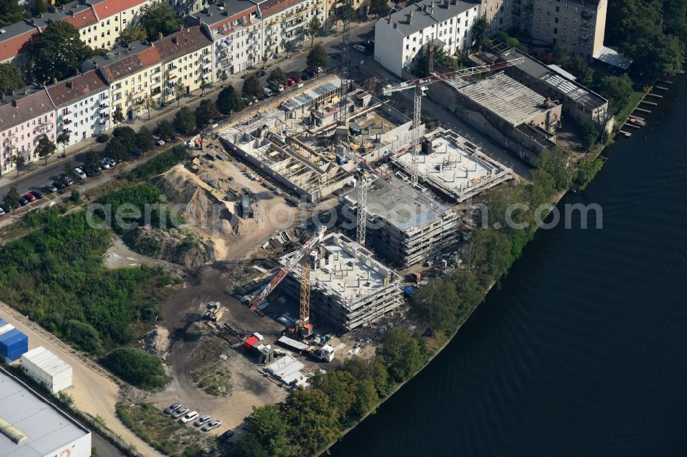 Berlin from above - Construction site of the MBN Bau AG to build a new multi-family residential complex in the Tabbertstrasse on the river banks of the Spree in Berlin