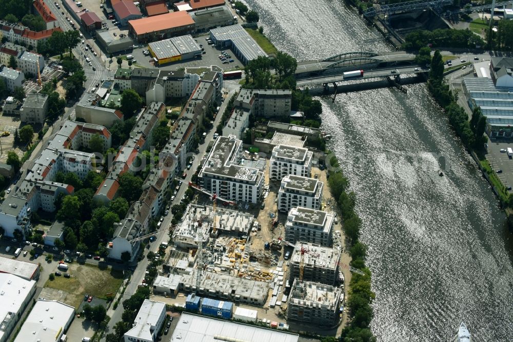 Berlin from above - Construction site of the MBN Bau AG and E.L.I.A. Bau- & Projektmanagement GmbH to build a new multi-family residential complex in the Tabbertstrasse in Schoeneweide on the river banks of the Spree in Berlin