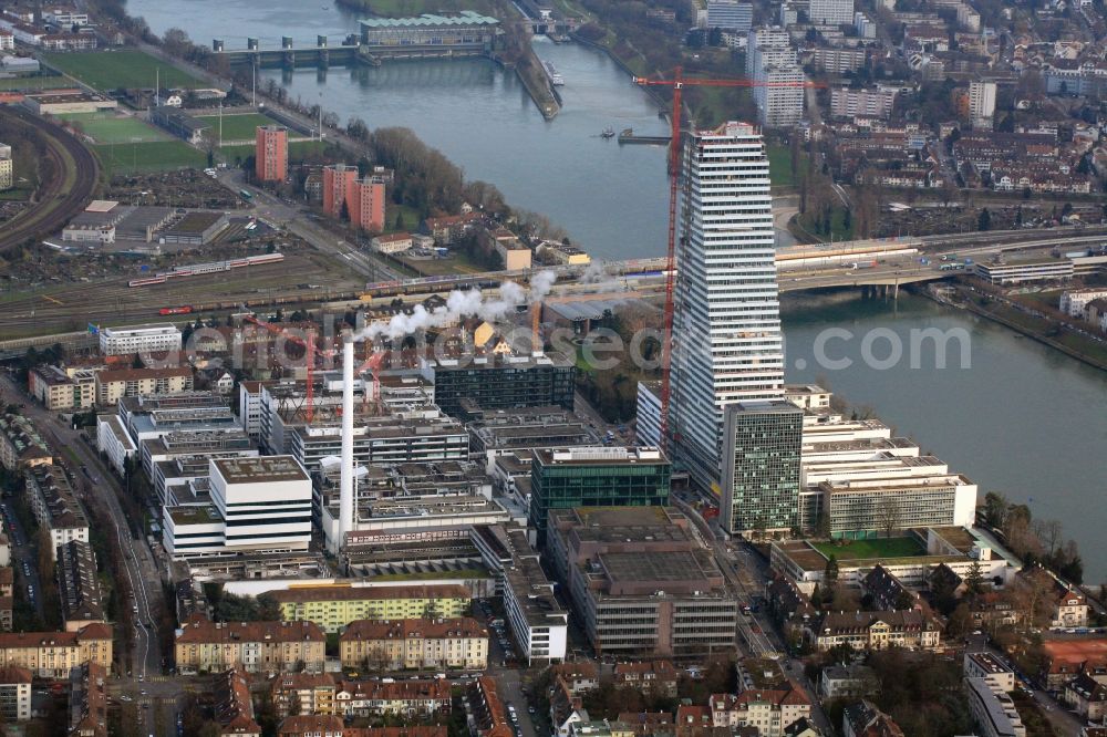 Basel from the bird's eye view: Constructionprogress on Roche Tower on the premises of the pharmaceutical company Hoffmann-La Roche AG, Basel, Switzerland. The overall height of the building of 178 meters is reached. Thus, the Roche Tower is the tallest building in Switzerland. Upon completion in 2015, planned by the Basel architects Herzog & de Meuron, the building will be the headquarters of Hoffmann-La Roche AG