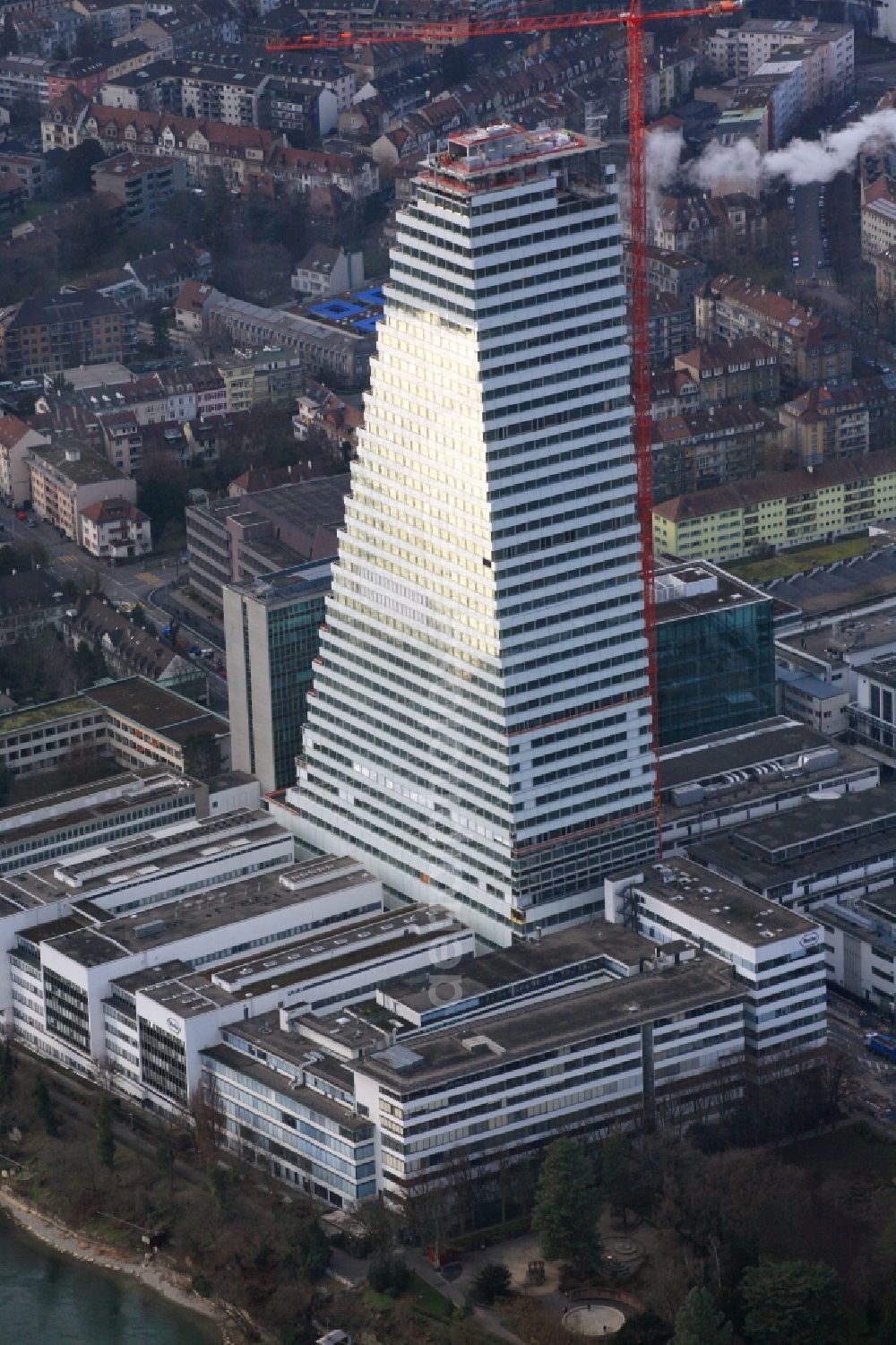 Basel from the bird's eye view: Constructionprogress on Roche Tower on the premises of the pharmaceutical company Hoffmann-La Roche AG, Basel, Switzerland. The overall height of the building of 178 meters is reached. Thus, the Roche Tower is the tallest building in Switzerland. Upon completion in 2015, planned by the Basel architects Herzog & de Meuron, the building will be the headquarters of Hoffmann-La Roche AG