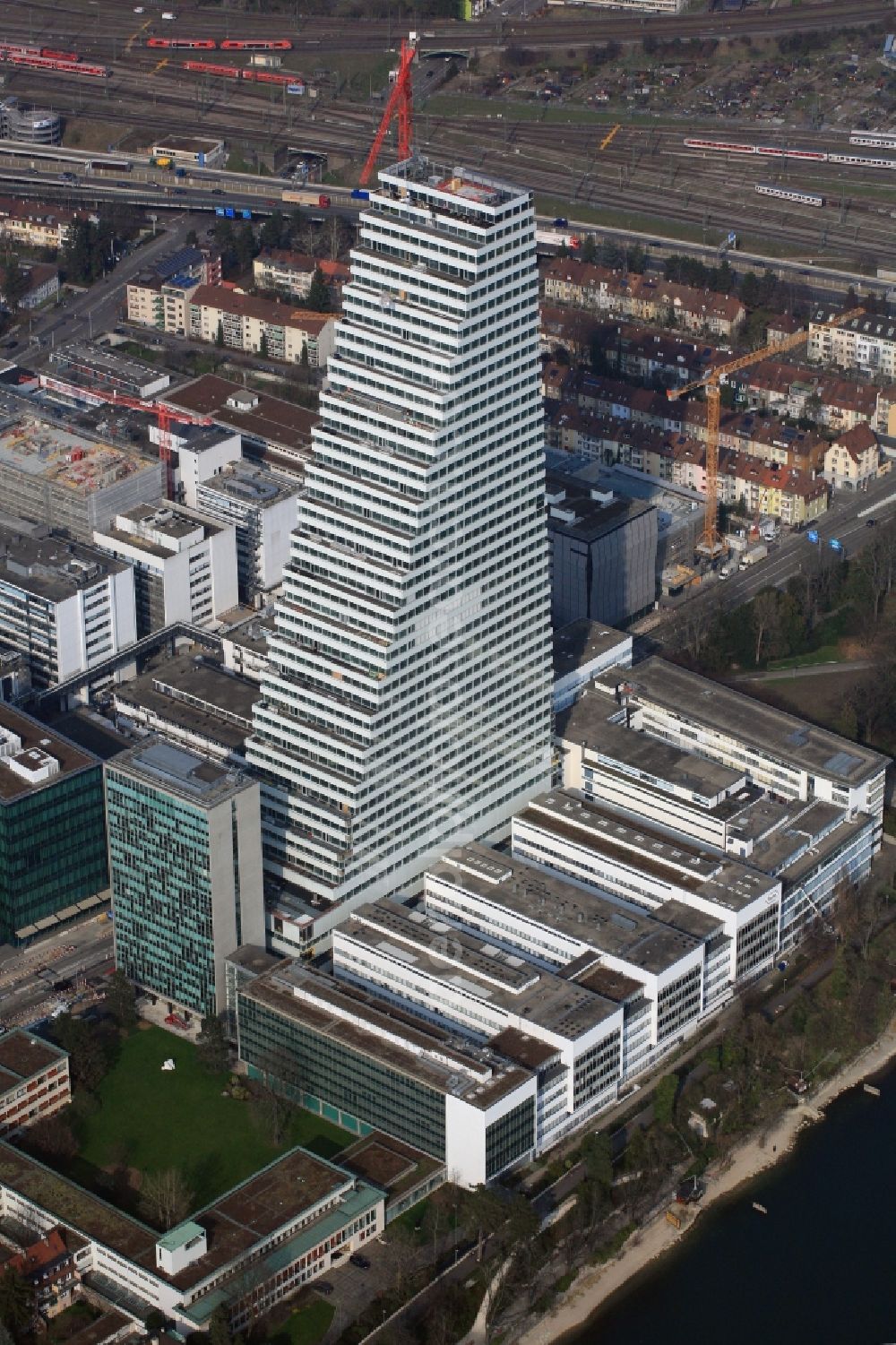 Aerial image Basel - Constructionprogress on Roche Tower on the premises of the pharmaceutical company Hoffmann-La Roche AG, Basel, Switzerland. The overall height of the building of 178 meters is reached. Thus, the Roche Tower is the tallest building in Switzerland. Upon completion in 2015, planned by the Basel architects Herzog & de Meuron, the building will be the headquarters of Hoffmann-La Roche AG