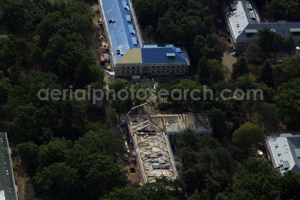 Berlin from the bird's eye view: Construction site for the new building of residential buildings on the compound of the former children's home Makarenko in the Johannisthal part of Berlin in Germany. The compound with different buildings is located in the forest area of Koenigsheide. A new residential estate is being built