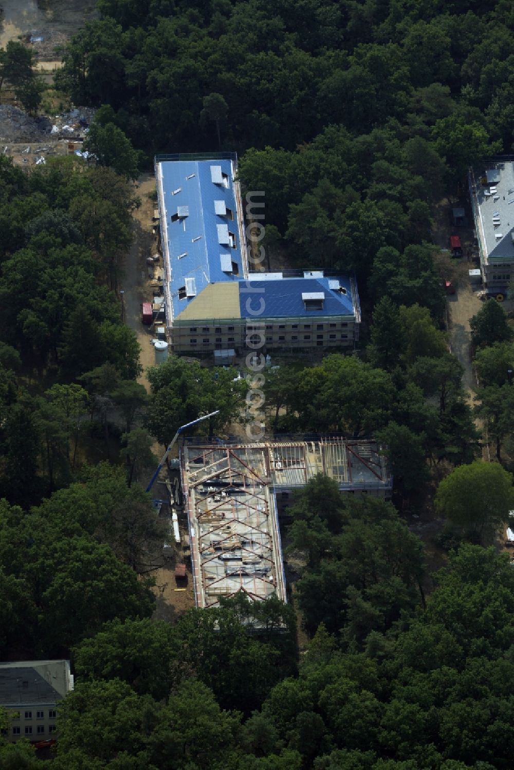 Aerial image Berlin - Construction site for the new building of residential buildings on the compound of the former children's home Makarenko in the Johannisthal part of Berlin in Germany. The compound with different buildings is located in the forest area of Koenigsheide. A new residential estate is being built