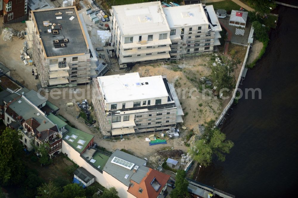 Berlin from above - Construction site for the new building of an appartment building complex on the seafront of Mueggelsee in the Friedrichshagen part of Berlin in Germany. The compound includes three residential buildings. The building project and construction site is located right on the shores of the lake