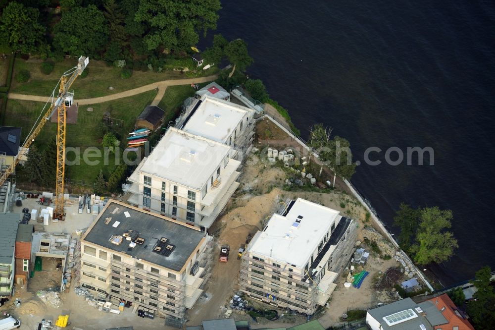 Aerial image Berlin - Construction site for the new building of an appartment building complex on the seafront of Mueggelsee in the Friedrichshagen part of Berlin in Germany. The compound includes three residential buildings. The building project and construction site is located right on the shores of the lake