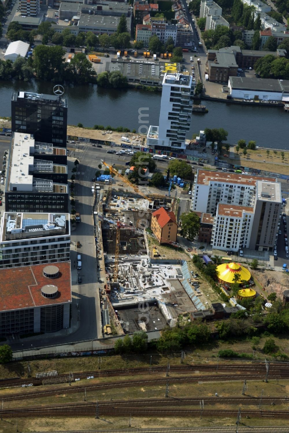 Aerial photograph Berlin - Construction site of a residential high rise complex on the Northern riverbank of the river Spree in the Friedrichshain part of Berlin in Germany. The apartment buildings and towers are being built on Mariane-Von-Rantzau Strasse in close vicinity of the Mercedes Benz distribution headquarters Germany and newly built residential buildings. The two towers are a project of Wohnkompanie and are being called Max & Moritz