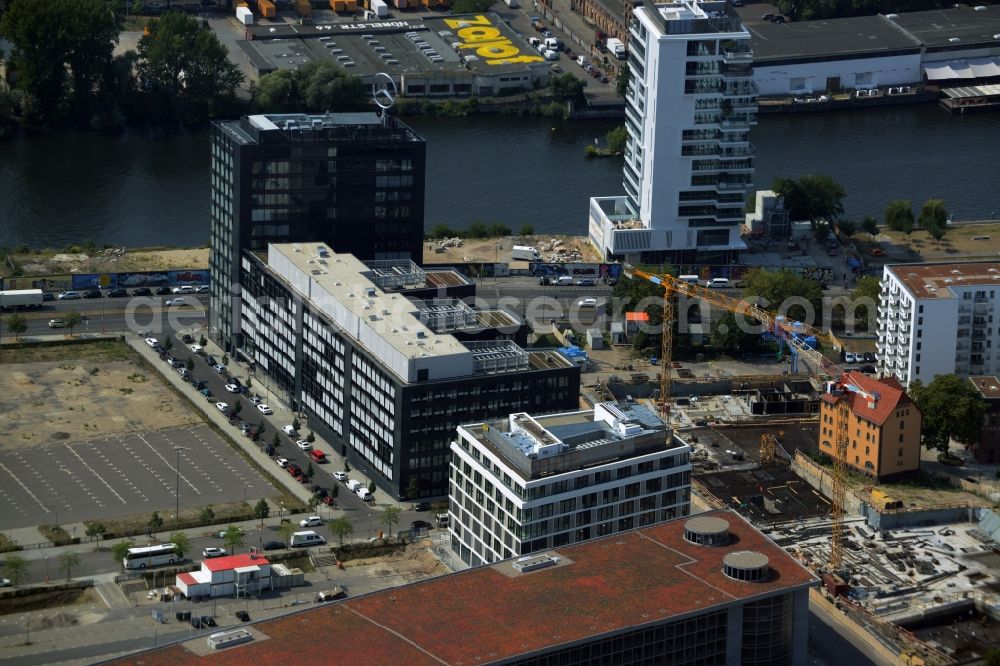 Aerial photograph Berlin - Construction site of a residential high rise complex on the Northern riverbank of the river Spree in the Friedrichshain part of Berlin in Germany. The apartment buildings and towers are being built on Mariane-Von-Rantzau Strasse in close vicinity of the Mercedes Benz distribution headquarters Germany and newly built residential buildings. The two towers are a project of Wohnkompanie and are being called Max & Moritz