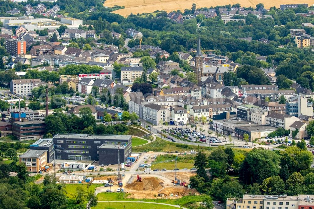 Heiligenhaus from the bird's eye view: Construction site of the new campus building of the Bochum University of Applied Sciences on Kettwiger Strasse in Heiligenhaus in the state of North Rhine-Westphalia. The town center with St.Suitbertus church is visible in the background