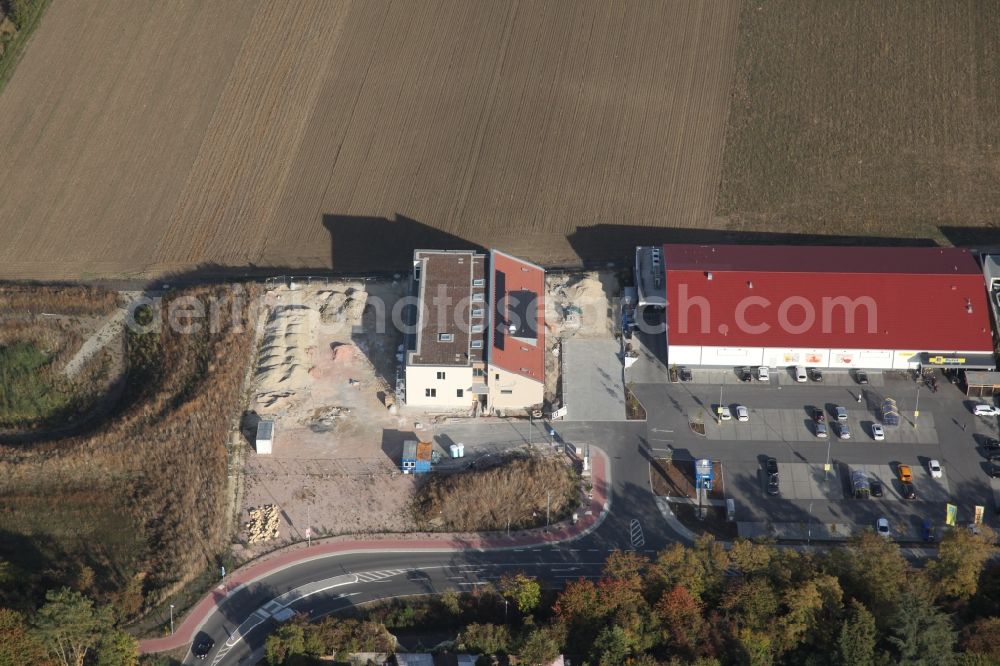 Gau-Bischofsheim from the bird's eye view: New construction site for the construction of a kindergarten building and Nursery school next to an Edeka food market, (red roof) in Gau-Bischofsheim in the state Rhineland-Palatinate, Germany