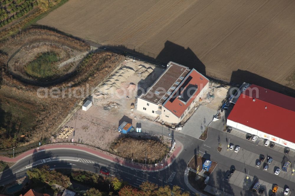 Aerial image Gau-Bischofsheim - New construction site for the construction of a kindergarten building and Nursery school next to an Edeka food market, (red roof) in Gau-Bischofsheim in the state Rhineland-Palatinate, Germany