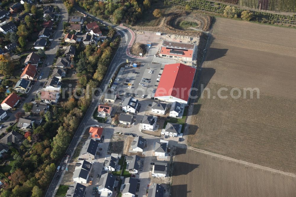 Aerial photograph Gau-Bischofsheim - New construction site for the construction of a kindergarten building and Nursery school next to an Edeka food market, (red roof) in Gau-Bischofsheim in the state Rhineland-Palatinate, Germany