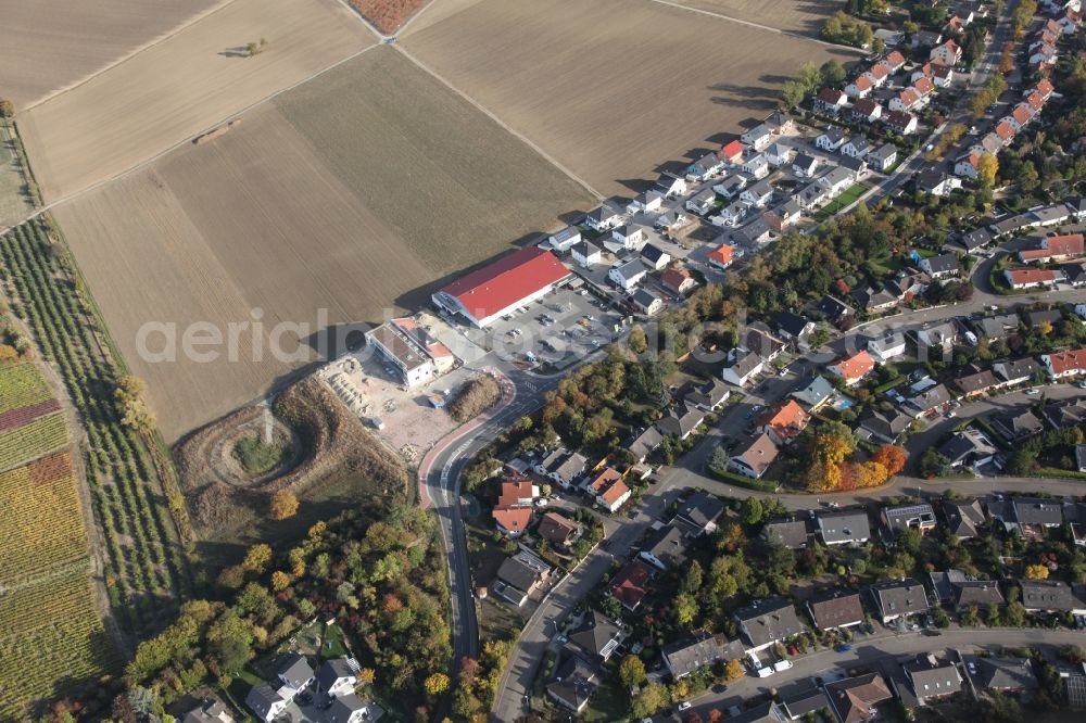 Aerial photograph Gau-Bischofsheim - New construction site for the construction of a kindergarten building and Nursery school next to an Edeka food market, (red roof) in Gau-Bischofsheim in the state Rhineland-Palatinate, Germany