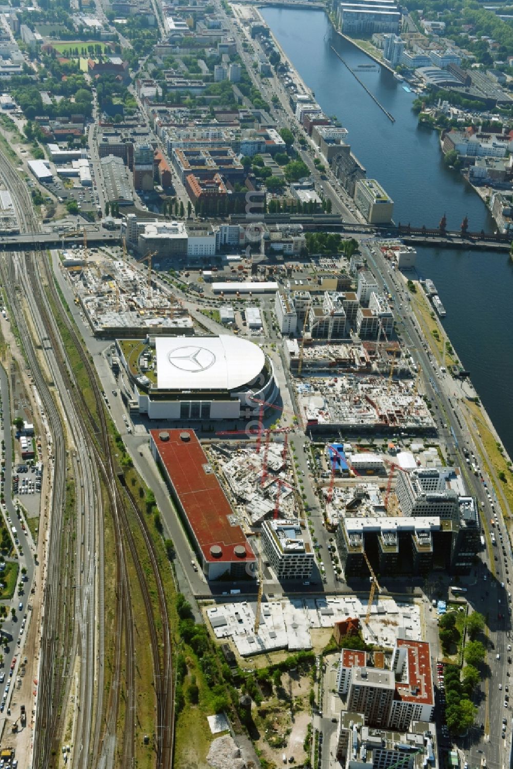 Berlin from the bird's eye view: Development area and construction sites on the Anschutzareal at the Mercedes-Benz-Arena on the banks of the River Spree in Friedrichshain. The Anschutz Entertainment Group (AEG) is developing the site through numerous hotel and commercial building new buildings