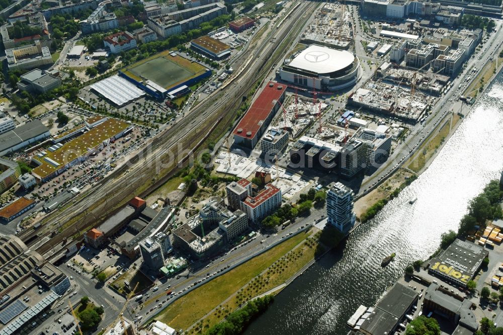 Berlin from the bird's eye view: Development area and construction sites on the Anschutzareal at the Mercedes-Benz-Arena on the banks of the River Spree in Friedrichshain. The Anschutz Entertainment Group (AEG) is developing the site through numerous hotel and commercial building new buildings