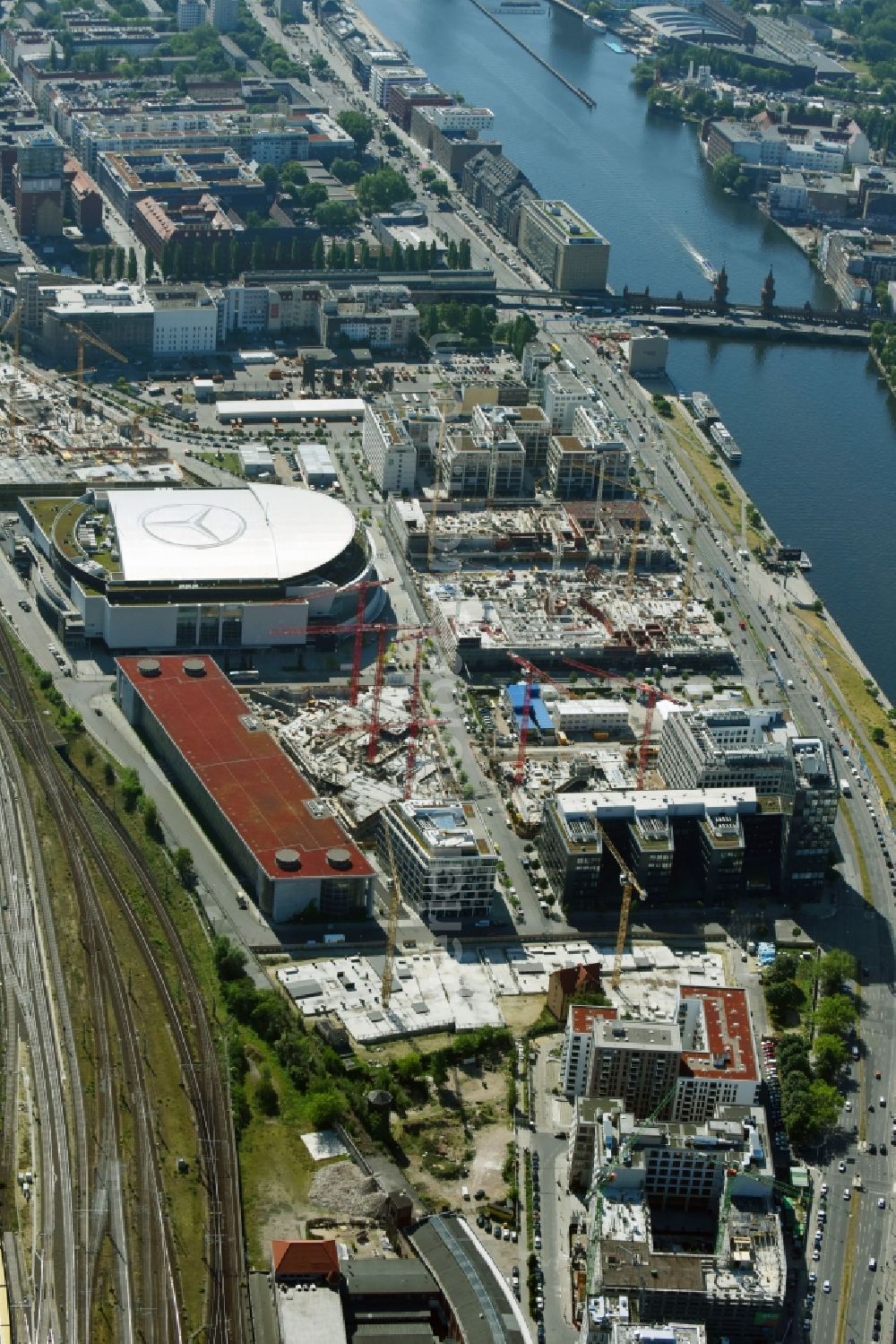 Aerial photograph Berlin - Development area and construction sites on the Anschutzareal at the Mercedes-Benz-Arena on the banks of the River Spree in Friedrichshain. The Anschutz Entertainment Group (AEG) is developing the site through numerous hotel and commercial building new buildings