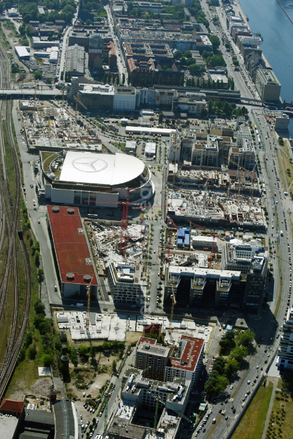 Berlin from the bird's eye view: Development area and construction sites on the Anschutzareal at the Mercedes-Benz-Arena on the banks of the River Spree in Friedrichshain. The Anschutz Entertainment Group (AEG) is developing the site through numerous hotel and commercial building new buildings