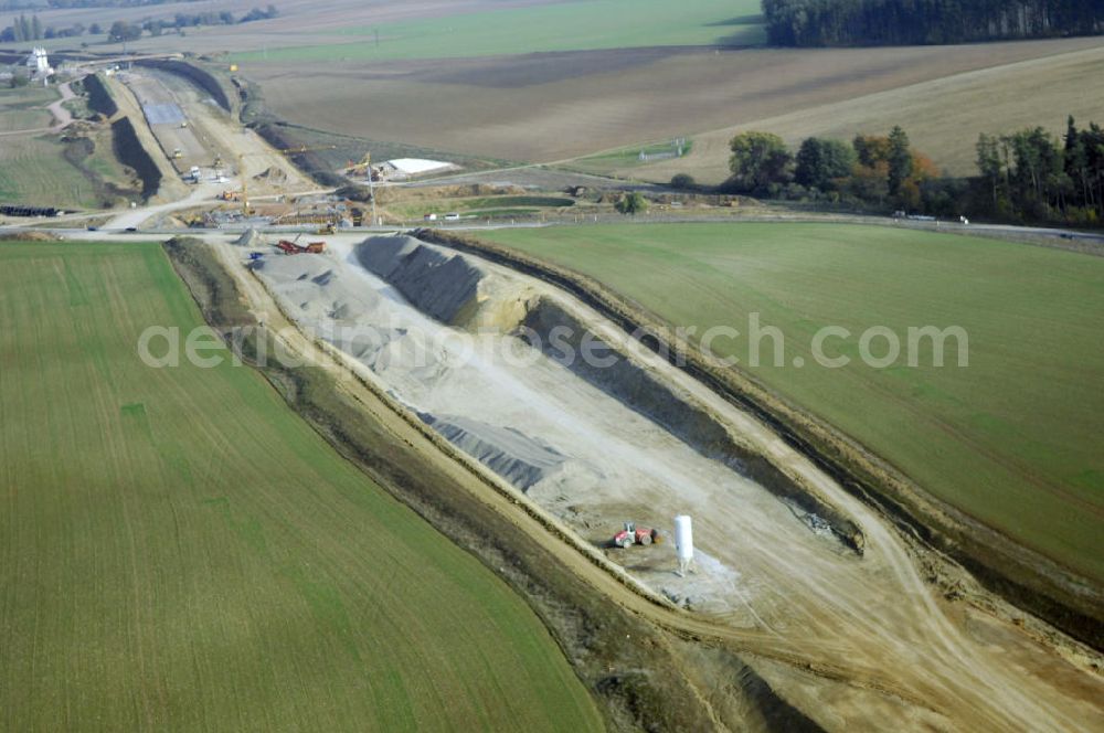 Aerial photograph Madelungen - Baustellen an der Neubautrasse der BAB A 4 - Umfahrung Hörselberge in Thüringen bei Eisenach. Das Bieterkonsortium VINCI Concessions / Hochtief PPP (50/50) hat den Zuschlag für das A-Modell BAB A 4 Umfahrung Hörselberge (km 238,5 bis km 283,2) erhalten. Die bei diesem Projekt auf der Bauausführungsebene gegründete Arbeitsgemeinschaft wird von der EUROVIA Infra GmbH angeführt, des Weiteren sind hier die Unternehmen Hochtief, Strassing Limes und Rädlinger beteiligt. Durchgeführt werden die im Zuge dieses Projektes notwendigen Arbeiten unter an derem von den Mitarbeitern der Niederlassung Weimar der EUROVIA Verkehrsbau Union sowie der Niederlassungen Abbruch und Erdbau, Betonstraßenbau, Ingenieurbau und TECO Schallschutz der EUROVIA Beton. DEGES; STREIF Baulogistik