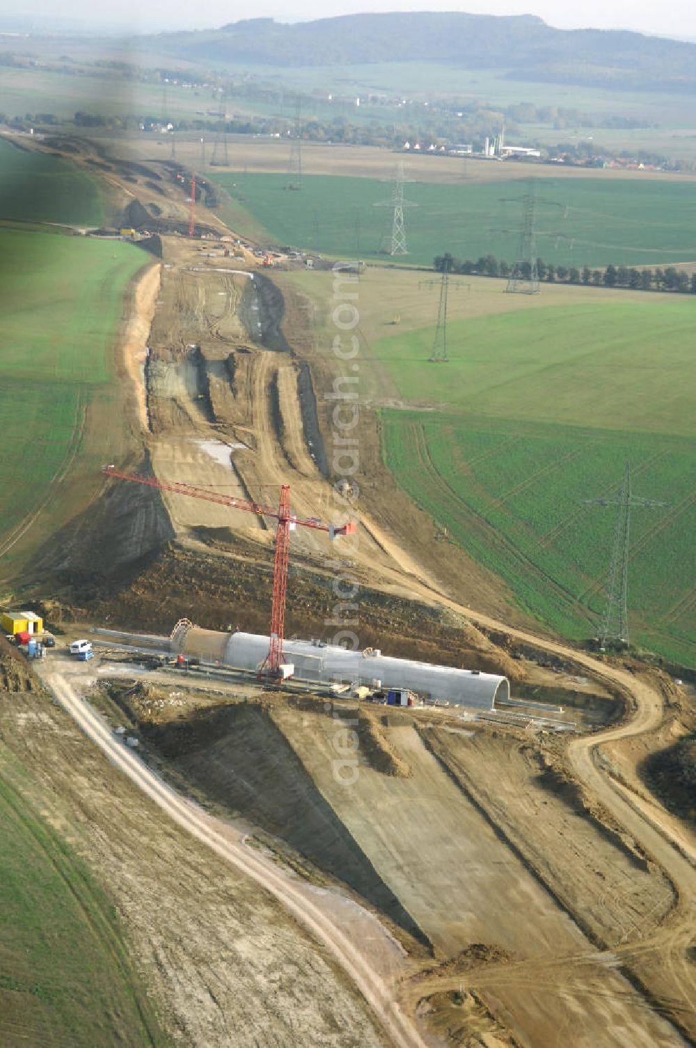 Aerial photograph Madelungen - Baustellen an der Neubautrasse der BAB A 4 - Umfahrung Hörselberge in Thüringen bei Eisenach. Das Bieterkonsortium VINCI Concessions / Hochtief PPP (50/50) hat den Zuschlag für das A-Modell BAB A 4 Umfahrung Hörselberge (km 238,5 bis km 283,2) erhalten. Die bei diesem Projekt auf der Bauausführungsebene gegründete Arbeitsgemeinschaft wird von der EUROVIA Infra GmbH angeführt, des Weiteren sind hier die Unternehmen Hochtief, Strassing Limes und Rädlinger beteiligt. Durchgeführt werden die im Zuge dieses Projektes notwendigen Arbeiten unter an derem von den Mitarbeitern der Niederlassung Weimar der EUROVIA Verkehrsbau Union sowie der Niederlassungen Abbruch und Erdbau, Betonstraßenbau, Ingenieurbau und TECO Schallschutz der EUROVIA Beton. DEGES; STREIF Baulogistik