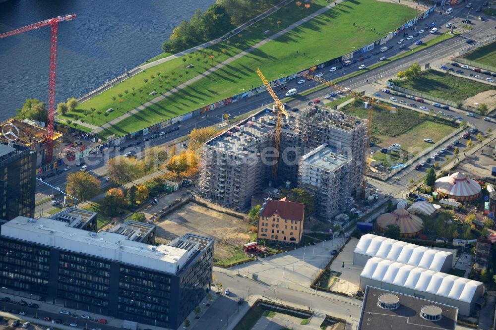 Berlin from the bird's eye view: Construction site by Schrobsdorff Bau AG to build a new apartment-house at Mühlenstrasse in Berlin Friedrichshain. The housing units with a view of the East Side Gallery on the banks of the river Spree will be in close proximity to the new headquarters of Mercedes-Benz Germany. The office of Dahm Architects & Engineers overviewed the planing of the project