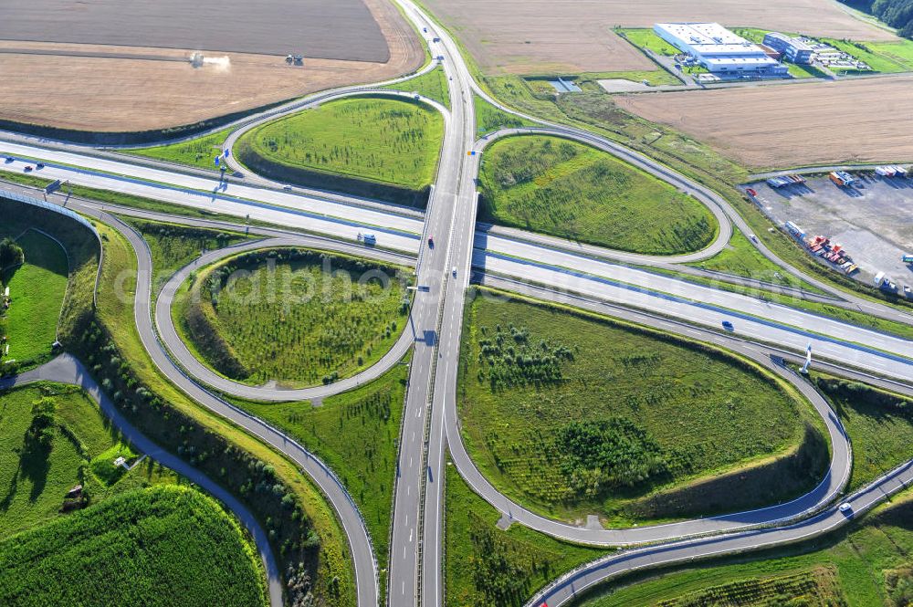 Triptis from the bird's eye view: Kreuz der Autobahnabfahrt der BAB Bundesautobahn A9 zur Bundesstraße B 281. Derzeit laufen Vorbereitungsarbeiten für den sechsspurigen Ausbau der Autobahn 9 zwischen Triptis und Schleiz durch das deutsch-französisches Konsortium EUROVIA VINCI. Es ist das letzte Projekt im Rahmen des Verkehrsprojekt Deutsche Einheit Nummer zwölf der DEGES. Buildings and route of the motorway A9.