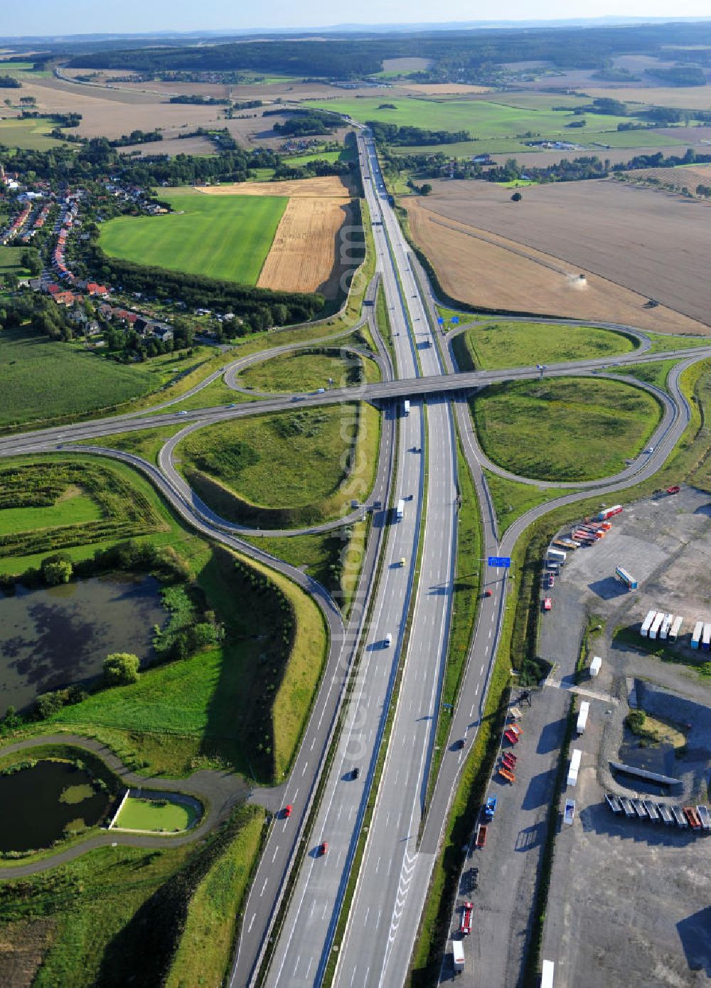 Aerial photograph Triptis - Kreuz der Autobahnabfahrt der BAB Bundesautobahn A9 zur Bundesstraße B 281. Derzeit laufen Vorbereitungsarbeiten für den sechsspurigen Ausbau der Autobahn 9 zwischen Triptis und Schleiz durch das deutsch-französisches Konsortium EUROVIA VINCI. Es ist das letzte Projekt im Rahmen des Verkehrsprojekt Deutsche Einheit Nummer zwölf der DEGES. Buildings and route of the motorway A9.