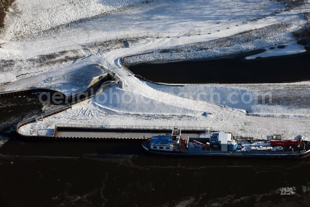 Elbe-Parey from the bird's eye view: In winter snow and ice parked weather specialized vessels on the banks of the Elbe-Havel canal in Guesen in Saxony-Anhalt