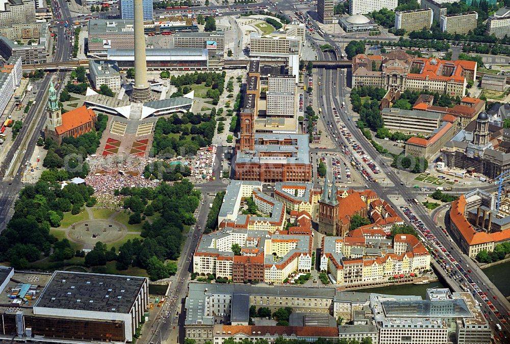 Berlin from the bird's eye view: View over the Nikolai Quarter on to the Public square Alexanderplatz with rail station, TV Tower, the Red City Hall, the St. Mary`s Church, the palce Marx-Engels-Forum and an demonstration at the Neptune Fountain in the district Mitte