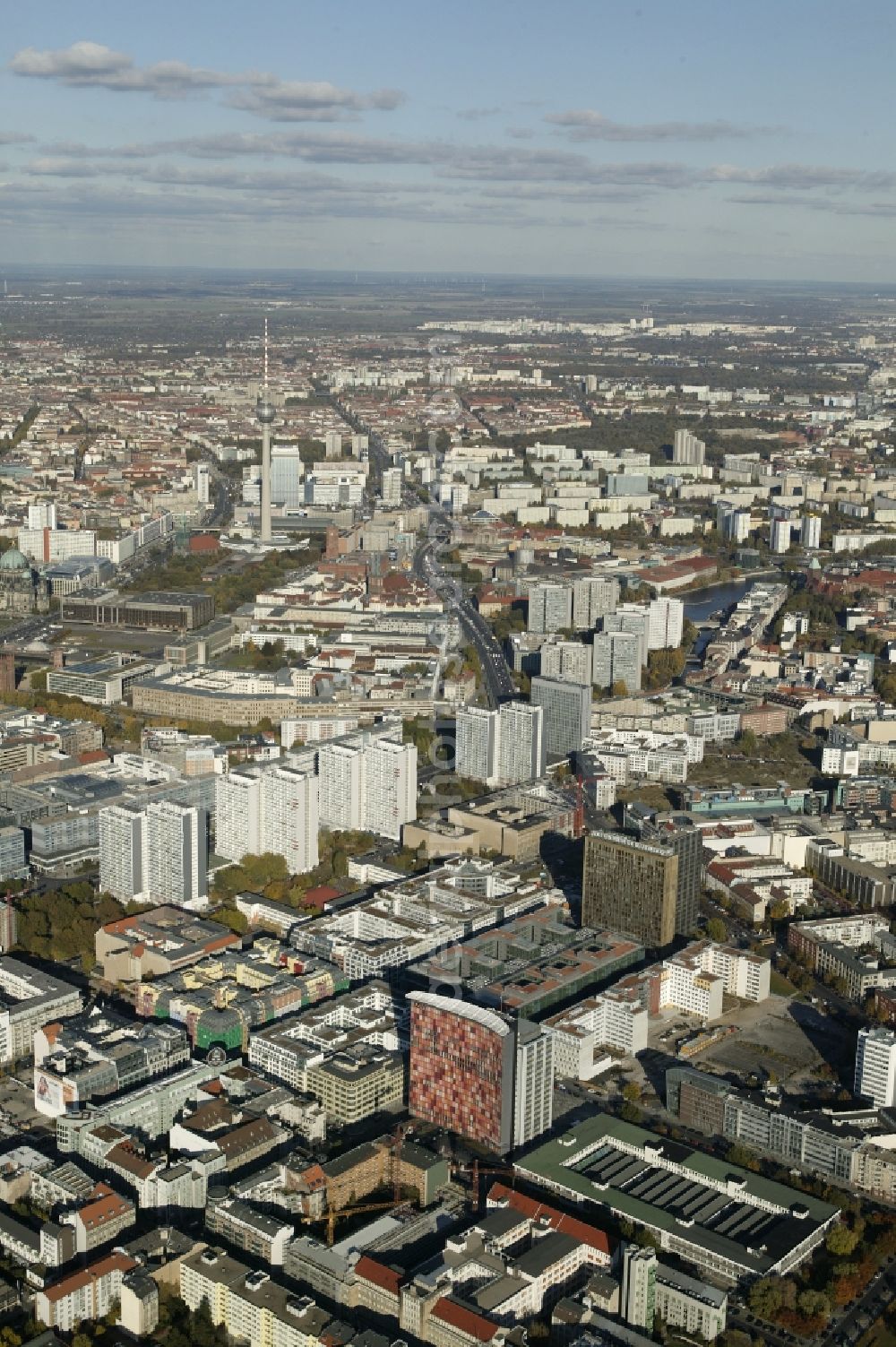 Berlin from the bird's eye view: Between the Zimmer Street, Linden Street and William Street in the Kreuzberg district of Berlin in the state of Berlin, a densely populated residential and commercial area with high-quality property extends. Here, large corporations and many agencies are established. Outstanding are the Axel-Springer premises and the high rise of the housing company GSW. The Leipziger Strasse, with its striking high-rise buildings from the communist era sought as wide traffic lane north. Before flowing into the Greifswalderstrasse it passes the Nikolai Quarter with the Nikolai Church and the Alexanderplatz with the Berlin TV Tower and the ParkInn hotel. In the city center there are also the Palace of the Republic, the Red City Hall and the Cathedral