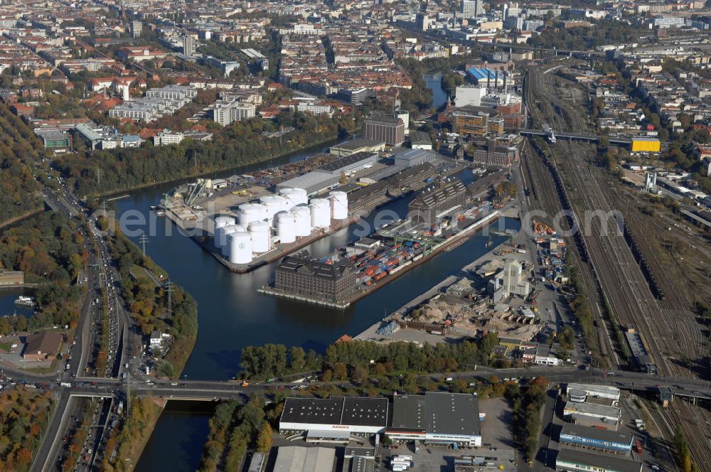 Berlin from the bird's eye view: Der Berliner Westhafen ist ein Binnenhafen im Ortsteil Moabit des Bezirks Mitte. Der Westhafen ist mit einer Fläche von 430.000 m² der größte Hafen der Stadt und ein bedeutender Umschlag- und Lagerplatz für die Binnenschifffahrt. Die Berliner Hafen-und Lagerhausgesellschaft mbH, kurz BEHALA genannt, betreibt in Berlin mehrere Binnenhäfen mit den dazugehörigen Lagerhäusern, dem Güterumschlag, einer Bauschuttentsorgung, den Hafenbahnen, und die Vermietung von Immobilien auf den Hafengeländen. Sie ist ein Eigenbetrieb der Stadt Berlin. Weitere Informationen unter