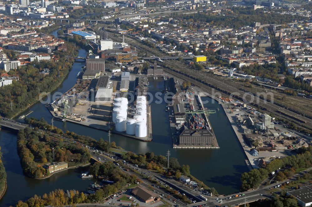 Aerial photograph Berlin - Der Berliner Westhafen ist ein Binnenhafen im Ortsteil Moabit des Bezirks Mitte. Der Westhafen ist mit einer Fläche von 430.000 m² der größte Hafen der Stadt und ein bedeutender Umschlag- und Lagerplatz für die Binnenschifffahrt. Die Berliner Hafen-und Lagerhausgesellschaft mbH, kurz BEHALA genannt, betreibt in Berlin mehrere Binnenhäfen mit den dazugehörigen Lagerhäusern, dem Güterumschlag, einer Bauschuttentsorgung, den Hafenbahnen, und die Vermietung von Immobilien auf den Hafengeländen. Sie ist ein Eigenbetrieb der Stadt Berlin. Weitere Informationen unter