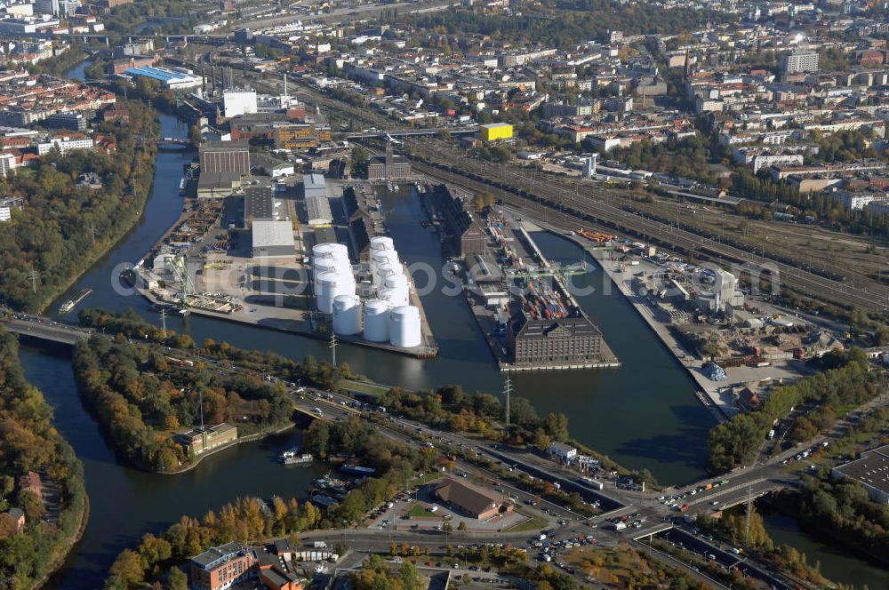 Berlin from the bird's eye view: Der Berliner Westhafen ist ein Binnenhafen im Ortsteil Moabit des Bezirks Mitte. Der Westhafen ist mit einer Fläche von 430.000 m² der größte Hafen der Stadt und ein bedeutender Umschlag- und Lagerplatz für die Binnenschifffahrt. Die Berliner Hafen-und Lagerhausgesellschaft mbH, kurz BEHALA genannt, betreibt in Berlin mehrere Binnenhäfen mit den dazugehörigen Lagerhäusern, dem Güterumschlag, einer Bauschuttentsorgung, den Hafenbahnen, und die Vermietung von Immobilien auf den Hafengeländen. Sie ist ein Eigenbetrieb der Stadt Berlin. Weitere Informationen unter