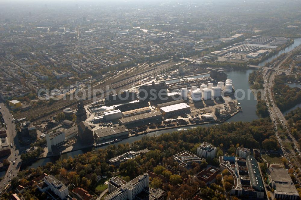 Berlin from the bird's eye view: Der Berliner Westhafen ist ein Binnenhafen im Ortsteil Moabit des Bezirks Mitte. Der Westhafen ist mit einer Fläche von 430.000 m² der größte Hafen der Stadt und ein bedeutender Umschlag- und Lagerplatz für die Binnenschifffahrt. Die Berliner Hafen-und Lagerhausgesellschaft mbH, kurz BEHALA genannt, betreibt in Berlin mehrere Binnenhäfen mit den dazugehörigen Lagerhäusern, dem Güterumschlag, einer Bauschuttentsorgung, den Hafenbahnen, und die Vermietung von Immobilien auf den Hafengeländen. Sie ist ein Eigenbetrieb der Stadt Berlin. Weitere Informationen unter