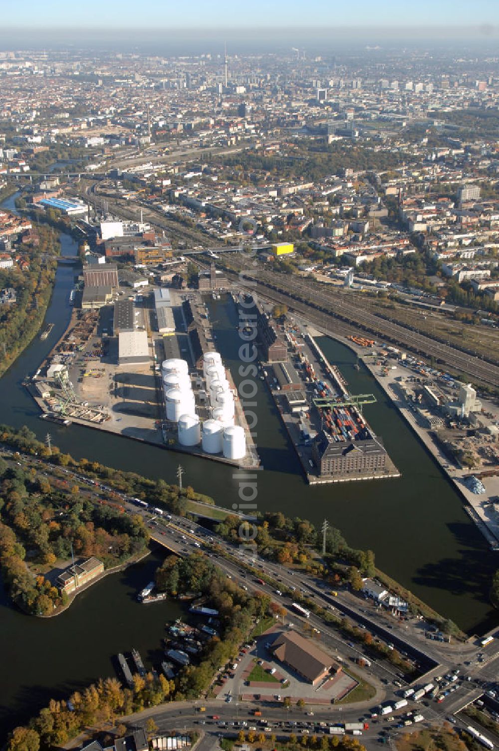 Berlin from above - Der Berliner Westhafen ist ein Binnenhafen im Ortsteil Moabit des Bezirks Mitte. Der Westhafen ist mit einer Fläche von 430.000 m² der größte Hafen der Stadt und ein bedeutender Umschlag- und Lagerplatz für die Binnenschifffahrt. Die Berliner Hafen-und Lagerhausgesellschaft mbH, kurz BEHALA genannt, betreibt in Berlin mehrere Binnenhäfen mit den dazugehörigen Lagerhäusern, dem Güterumschlag, einer Bauschuttentsorgung, den Hafenbahnen, und die Vermietung von Immobilien auf den Hafengeländen. Sie ist ein Eigenbetrieb der Stadt Berlin. Weitere Informationen unter