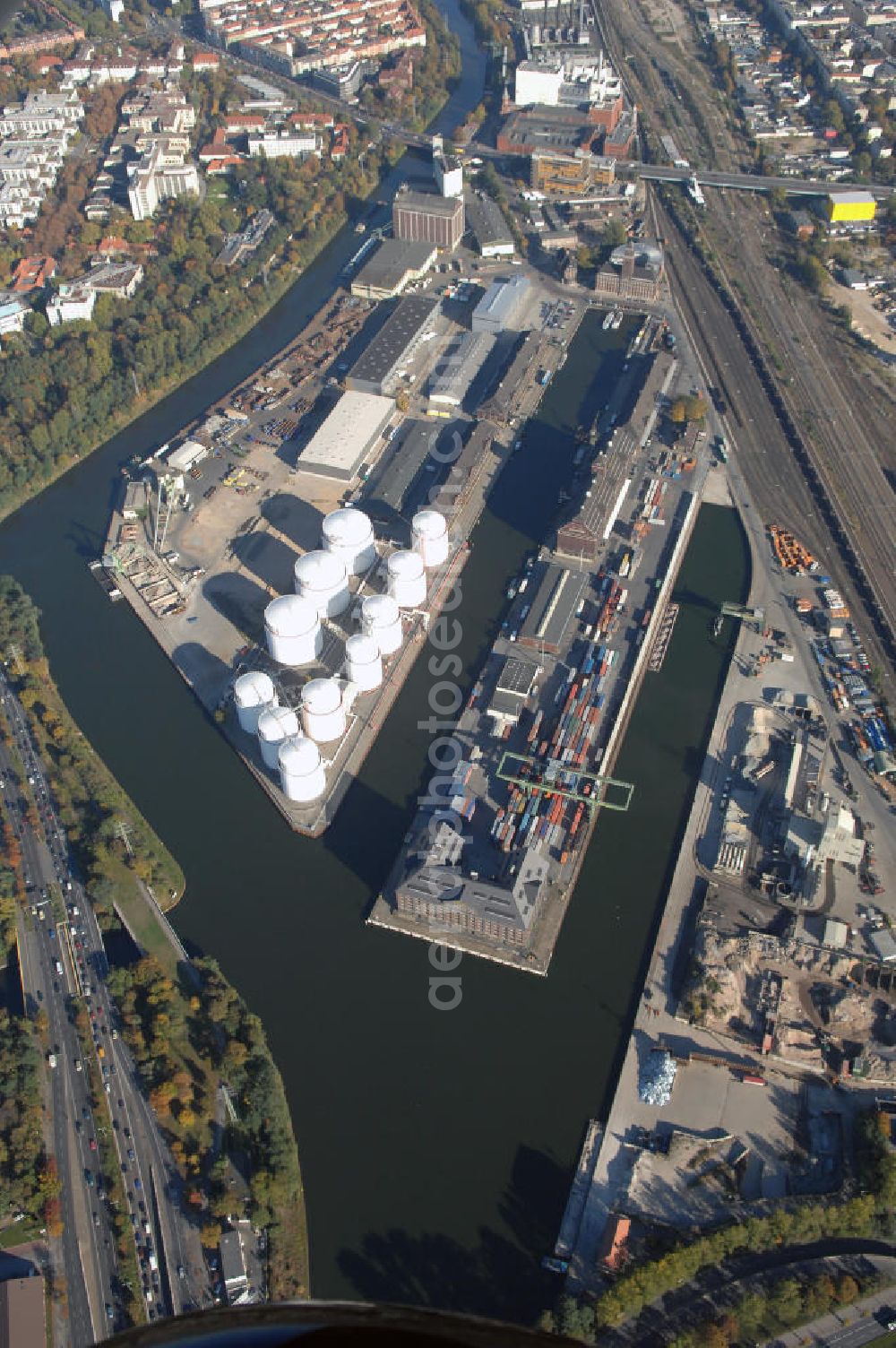 Berlin from above - Der Berliner Westhafen ist ein Binnenhafen im Ortsteil Moabit des Bezirks Mitte. Der Westhafen ist mit einer Fläche von 430.000 m² der größte Hafen der Stadt und ein bedeutender Umschlag- und Lagerplatz für die Binnenschifffahrt. Die Berliner Hafen-und Lagerhausgesellschaft mbH, kurz BEHALA genannt, betreibt in Berlin mehrere Binnenhäfen mit den dazugehörigen Lagerhäusern, dem Güterumschlag, einer Bauschuttentsorgung, den Hafenbahnen, und die Vermietung von Immobilien auf den Hafengeländen. Sie ist ein Eigenbetrieb der Stadt Berlin. Weitere Informationen unter