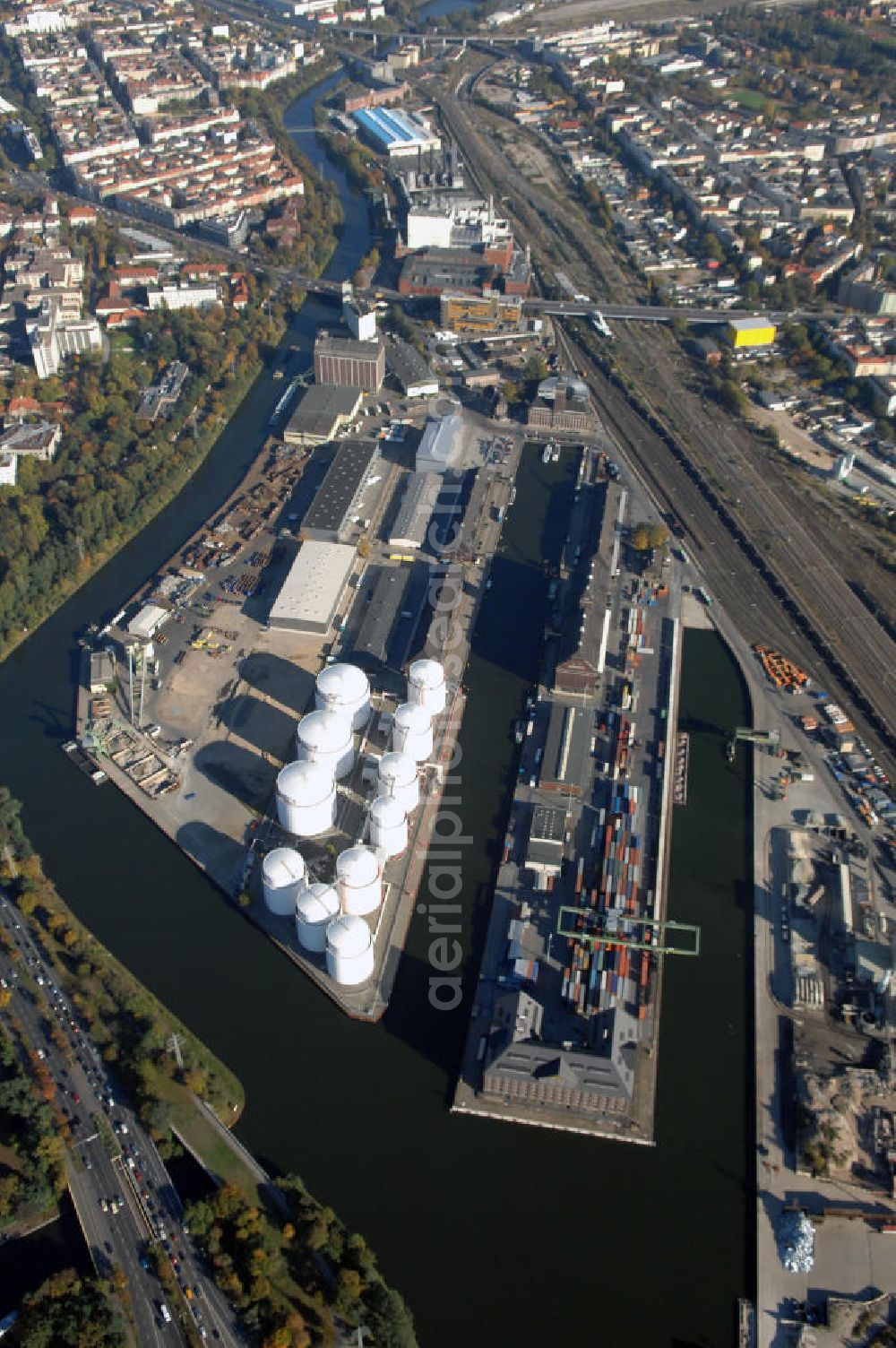 Berlin from the bird's eye view: Der Berliner Westhafen ist ein Binnenhafen im Ortsteil Moabit des Bezirks Mitte. Der Westhafen ist mit einer Fläche von 430.000 m² der größte Hafen der Stadt und ein bedeutender Umschlag- und Lagerplatz für die Binnenschifffahrt. Die Berliner Hafen-und Lagerhausgesellschaft mbH, kurz BEHALA genannt, betreibt in Berlin mehrere Binnenhäfen mit den dazugehörigen Lagerhäusern, dem Güterumschlag, einer Bauschuttentsorgung, den Hafenbahnen, und die Vermietung von Immobilien auf den Hafengeländen. Sie ist ein Eigenbetrieb der Stadt Berlin. Weitere Informationen unter