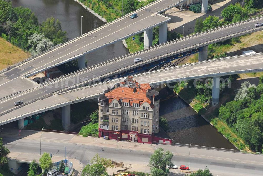 Berlin from the bird's eye view: Berlins verkehrsgünstigst gelegenes Haus, die Rattenburg Gottlieb-Dunkel-Straße 19. Sie sollte schon mehrmals abgerissen werden, so zum Bau der A100 in den 70ern und zur Vergrößerung des Teltow-Kanals in den 90ern. Doch Eigentümer und Mieter haben sich erfolgreich zur Wehr gesetzt: Statt Abriss wurde das Fundament aufwendig saniert.