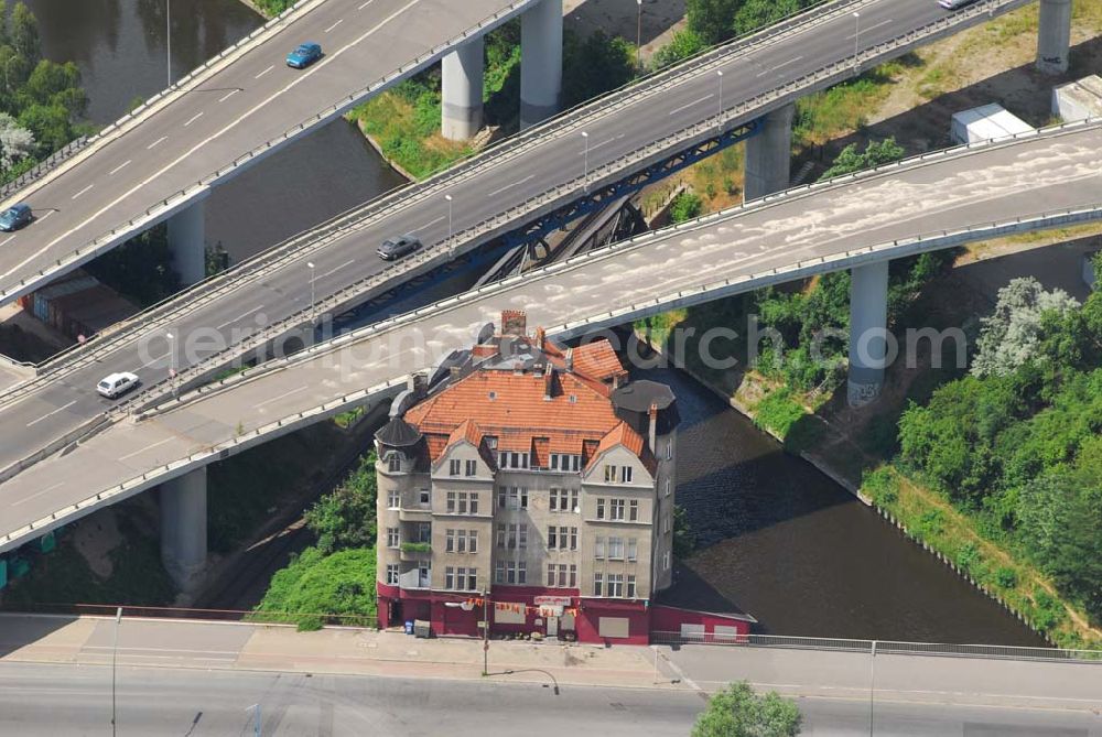 Aerial image Berlin - Berlins verkehrsgünstigst gelegenes Haus, die Rattenburg Gottlieb-Dunkel-Straße 19. Sie sollte schon mehrmals abgerissen werden, so zum Bau der A100 in den 70ern und zur Vergrößerung des Teltow-Kanals in den 90ern. Doch Eigentümer und Mieter haben sich erfolgreich zur Wehr gesetzt: Statt Abriss wurde das Fundament aufwendig saniert.