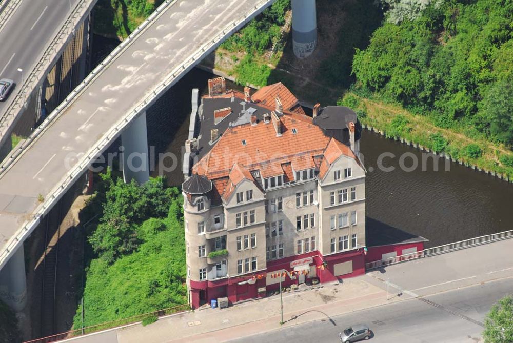 Aerial photograph Berlin - Berlins verkehrsgünstigst gelegenes Haus, die Rattenburg Gottlieb-Dunkel-Straße 19. Sie sollte schon mehrmals abgerissen werden, so zum Bau der A100 in den 70ern und zur Vergrößerung des Teltow-Kanals in den 90ern. Doch Eigentümer und Mieter haben sich erfolgreich zur Wehr gesetzt: Statt Abriss wurde das Fundament aufwendig saniert.