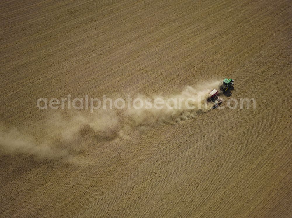 Aerial image Dohma - Cultivation of a field using a tractor with agricultural machine for sowing on street Am Kirschberg in Dohma in the state Saxony, Germany