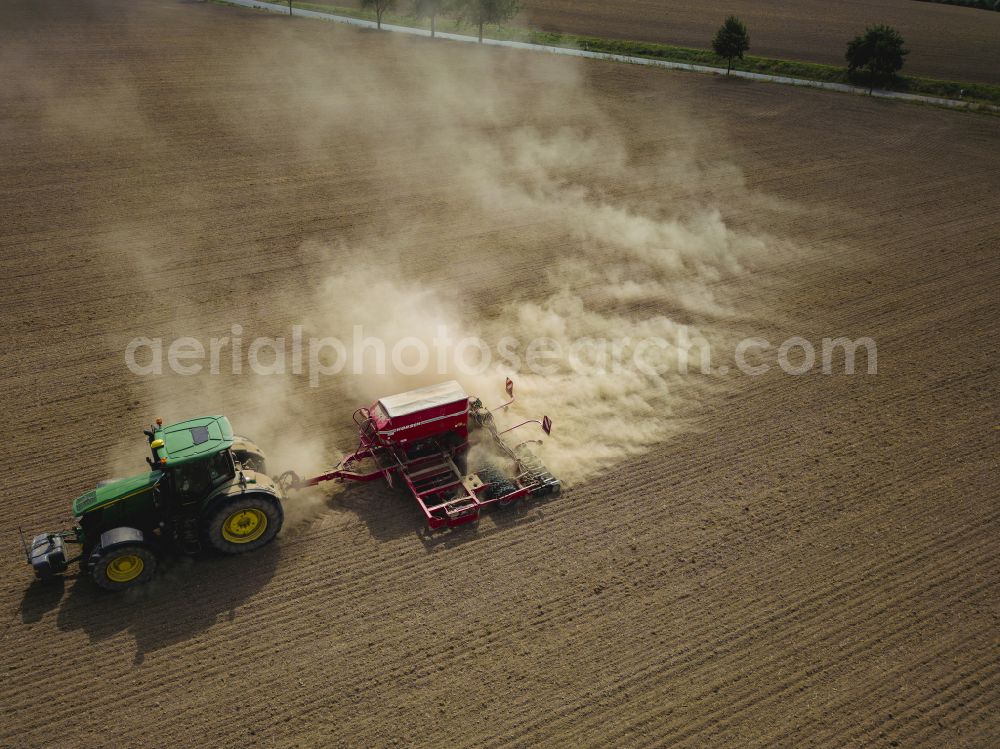 Aerial photograph Dohma - Cultivation of a field using a tractor with agricultural machine for sowing on street Am Kirschberg in Dohma in the state Saxony, Germany