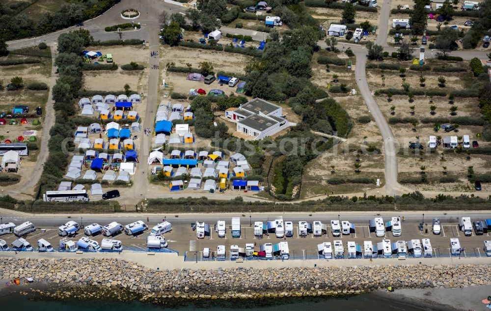 Saintes-Maries-de-la-Mer from the bird's eye view: Visitors and tourists on Mediterranean sandy beach in Saintes-Maries-de-la-Mer, Provence-Alpes-Cote d'Azur in France