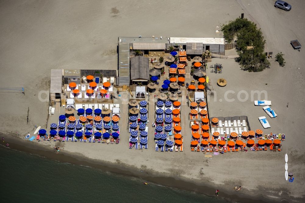 Aerial image Saintes-Maries-de-la-Mer - Visitors and tourists on Mediterranean sandy beach in Saintes-Maries-de-la-Mer, Provence-Alpes-Cote d'Azur in France