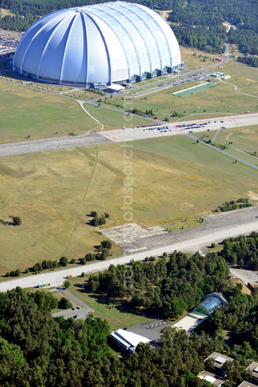 Aerial photograph Krausnick - View over the visitor centre Tropical Island, the former entrance hall and visitor center CargoLifter, to the largest self-supporting hall in the world in Krausnick in the state Brandenburg. The hall was originally built as an airship works by the CargoLifter company and was rebuilt by the Malaysian consortium of Tanjong PLC / Colin Au into the Tropical Islands Resort