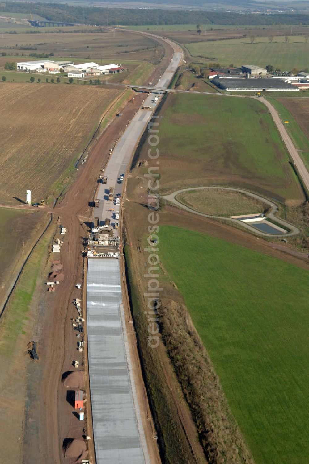 Aerial photograph Sättelstädt - Blick auf eine Betoniermaschine auf der Baustelle der A4 nahe dem Regenrückhaltebecken VI an der Ausfahrt / Anschlussstelle Sättelstädt. Der Neubau ist Teil des Projekt Nordverlegung / Umfahrung Hörselberge der Autobahn E40 / A4 in Thüringen bei Eisenach. Durchgeführt werden die im Zuge dieses Projektes notwendigen Arbeiten unter an derem von den Mitarbeitern der Niederlassung Weimar der EUROVIA Verkehrsbau Union sowie der Niederlassungen Abbruch und Erdbau, Betonstraßenbau, Ingenieurbau und TECO Schallschutz der EUROVIA Beton sowie der DEGES.