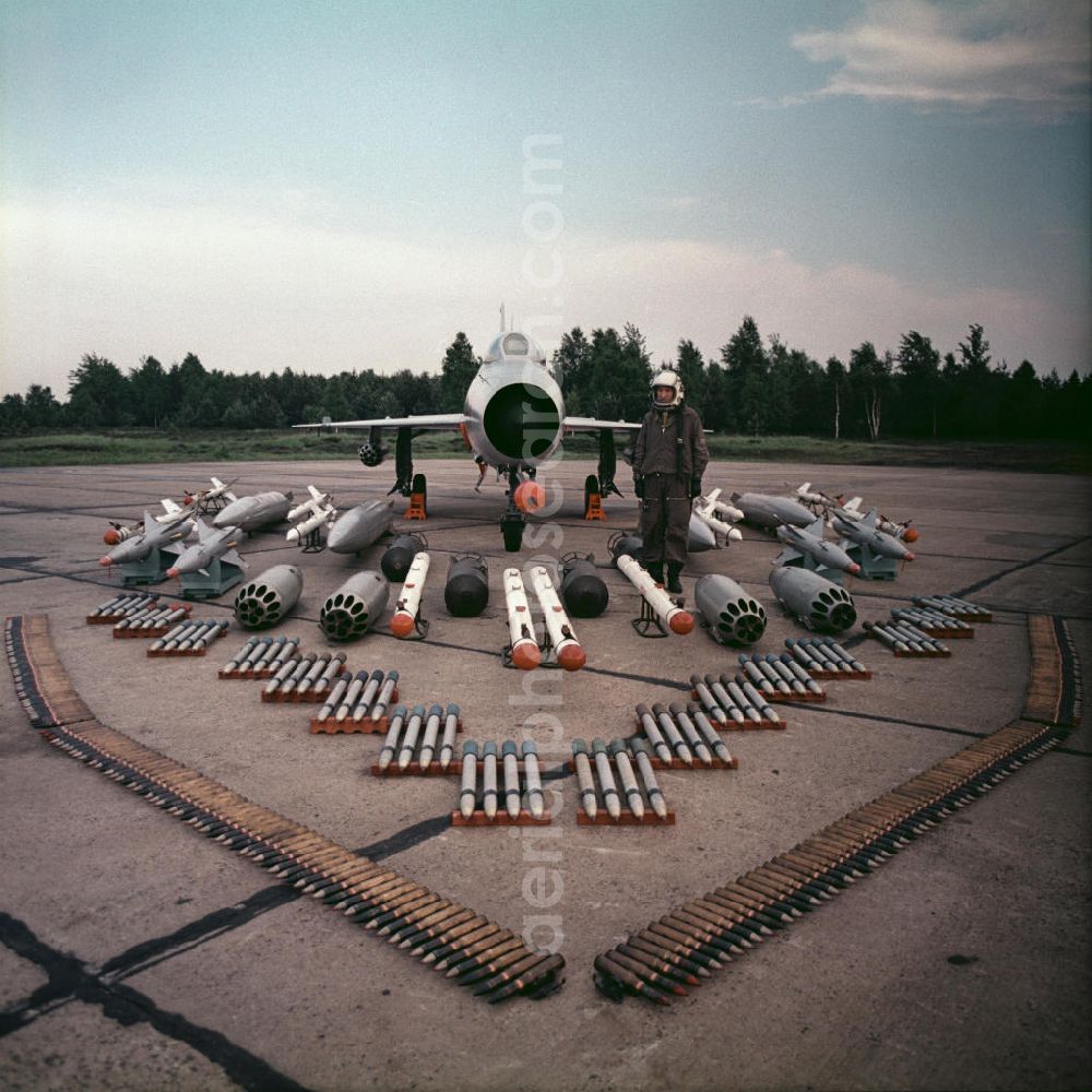 Drewitz from the bird's eye view: Blick auf die Bewaffnung einer Mikojan-Gurewitsch MiG-21 neben einem Jagdflieger / Piloten der NVA auf dem Flugplatz Cottbus-Drewitz. Der Abfangjäger MiG-21 ist das seit dem Zweiten Weltkrieg meistgebaute Kampfflugzeug der Welt. View of the arming of a Mikoyan-Gurevich MiG-21 next to a fighter pilot of the NVA. The interceptor MiG-21 is the most built fighter aircraft since the Second World War.