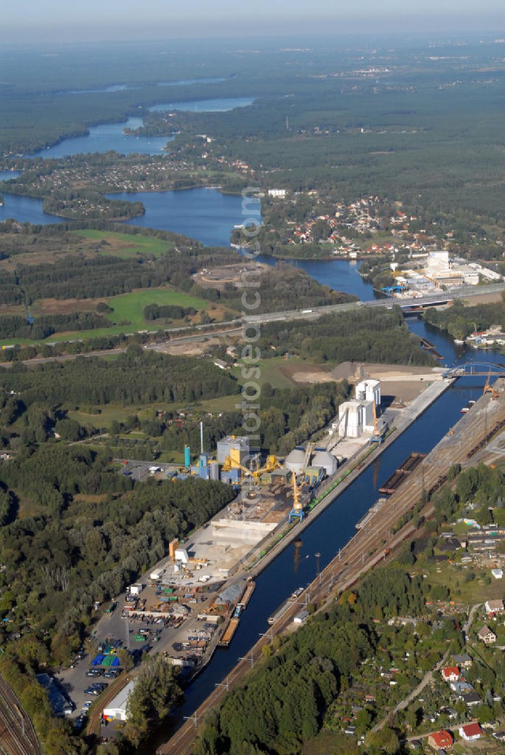 Königs Wusterhausen from above - Blick auf den Binnenhafen von Königs Wusterhausen und Wildau an der Dahme im Bundesland Brandenburg. Seine optimalen Verkehrsanbindungen des Binnenhafens, der sich in unmittelbarer Nähe zum Schönefelder Kreuz befindet, haben den Umschlagsplatz zu einen der bedeutsamsten seiner Region heranwachsen lassen. Das ansässige Logistikunternehmen LUTRA GmbH hat sich optimal an die vorherrschenden Bedürfnisse angepasst. Anschrift LUTRA GmbH: LUTRA GmbH, Hafenstraße 18, 15711 Königs Wusterhausen; Postanschrift: LUTRA GmbH, Postfach 1124, 15701 Königs Wusterhausen; Ansprechpartner: Geschäftsführer Reinhard Schuster, Tel. +49(0)3375 671 0, Fax +49(0)3375 671 125