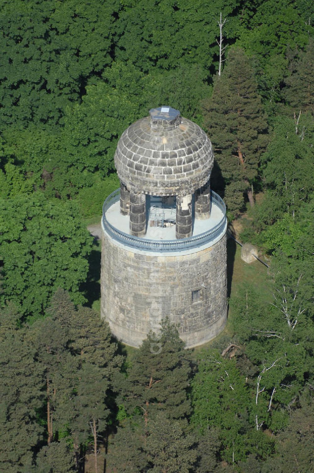 HALBERSTADT from above - Blick auf den Bismarckturm im Landschaftsschutzpark Spiegelsberge in Halberstadt. Seitlich von der Halle führen zwei Treppen mit 29 Kunststeinstufen zur ersten und 17 Eisenstufen einer Wendeltreppe zur Aussichtsplattform. Über der Aussichtsplattform erhebt sich auf fünf wuchtigen Säulen ein Kuppelbau mit rundem Feuerbecken. Nach dem 2. Weltkrieg wurde der Bismarckturm in Turm des Friedens umbenannt. Der Turm wurde nicht saniert. Im Jahr 1965 hatte man die Idee, den Turm in eine Volkssternwarte umzubauen. Dieser Gedanke wurde aber wieder verworfen. Nach der Wende wurde der Turm 1992 unter Denkmalschutz gestellt und in den Jahren 1996-98 saniert (Wiedereröffnung am 21.07.1998). Die Rückbenennung in Bismarckturm erfolgte ca. 1992.